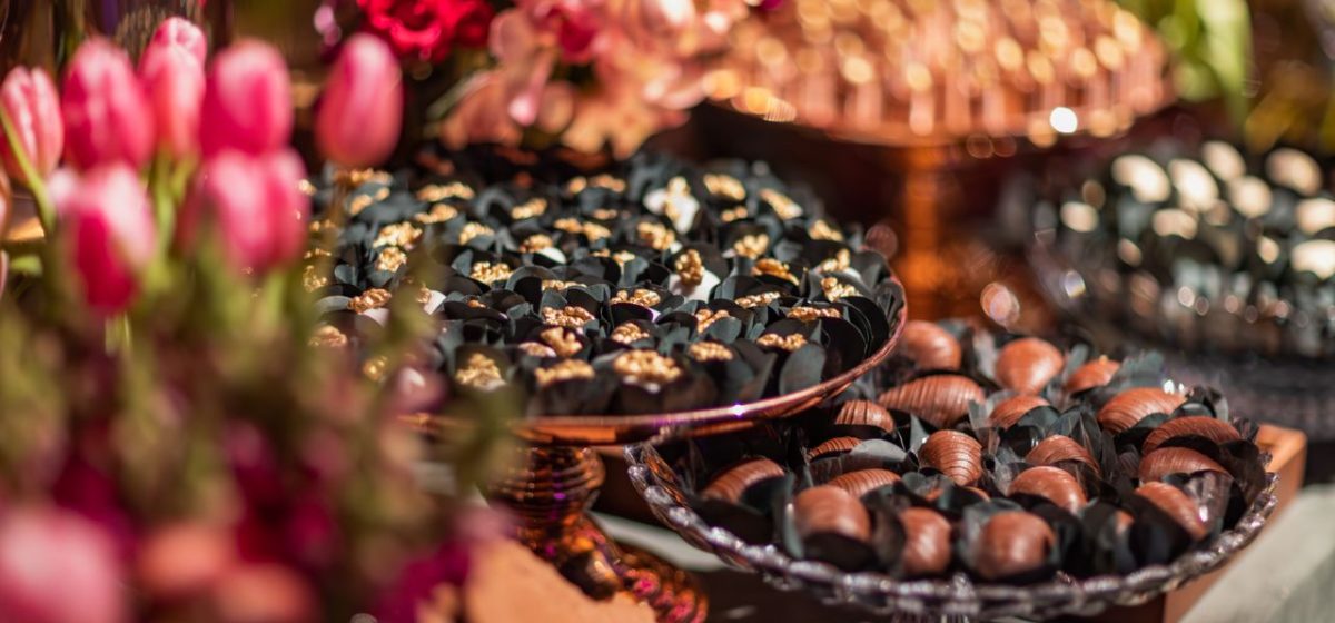 Close-up shot of assorted chocolates displayed with vibrant tulips, creating a luxurious setting.